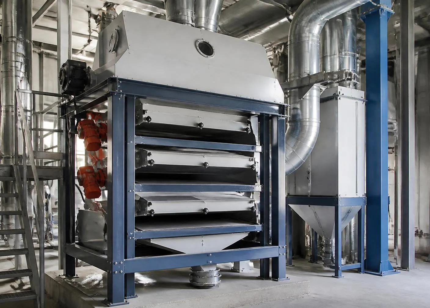 Commercial air-screen seed cleaner with stacked screen decks and aspiration ducting inside a seed conditioning plant